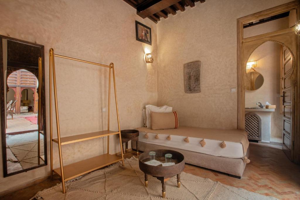 un salon avec un lit et une table dans l'établissement Riad Tassili Marrakech, à Marrakech