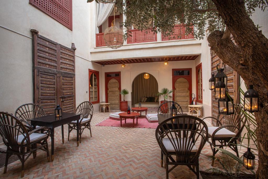 un patio avec des tables et des chaises et un bâtiment dans l'établissement Riad Tassili Marrakech, à Marrakech 37 autres photos