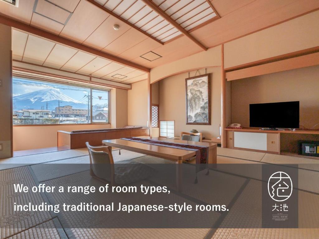 un salon avec une table et une télévision dans l'établissement Oike Hotel, à Fujikawaguchiko