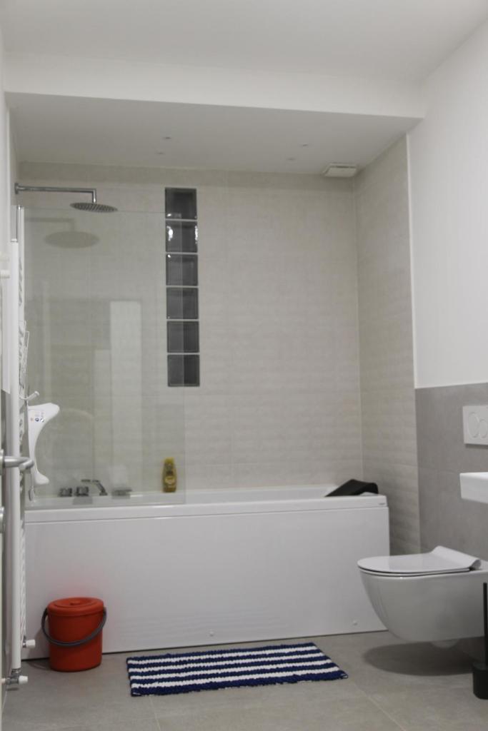 La salle de bains blanche est pourvue d'une baignoire et de toilettes. dans l'établissement Villa Petra, à Imperia