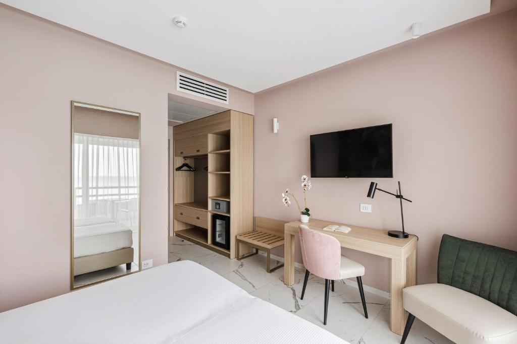 une chambre avec un lit, un bureau et une télévision dans l'établissement Aldiana Club Rocca Nettuno Calabria, à Tropea
