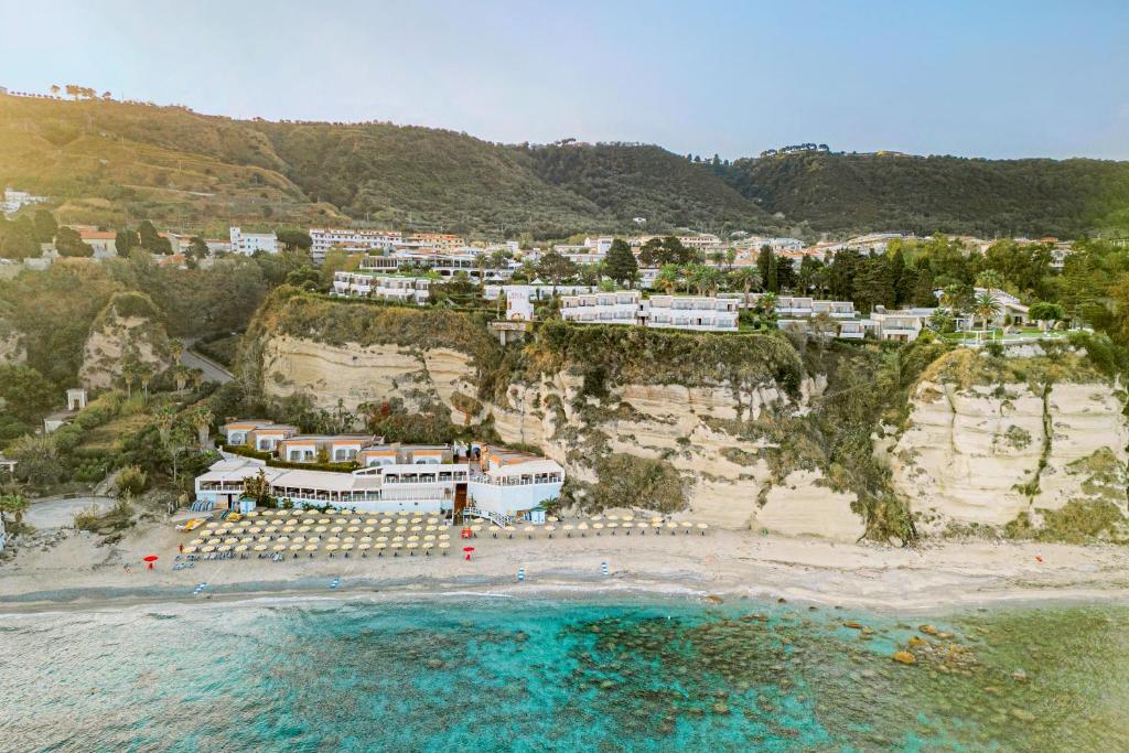 - une vue aérienne sur une plage avec des maisons sur une falaise dans l'établissement Aldiana Club Rocca Nettuno Calabria, à Tropea