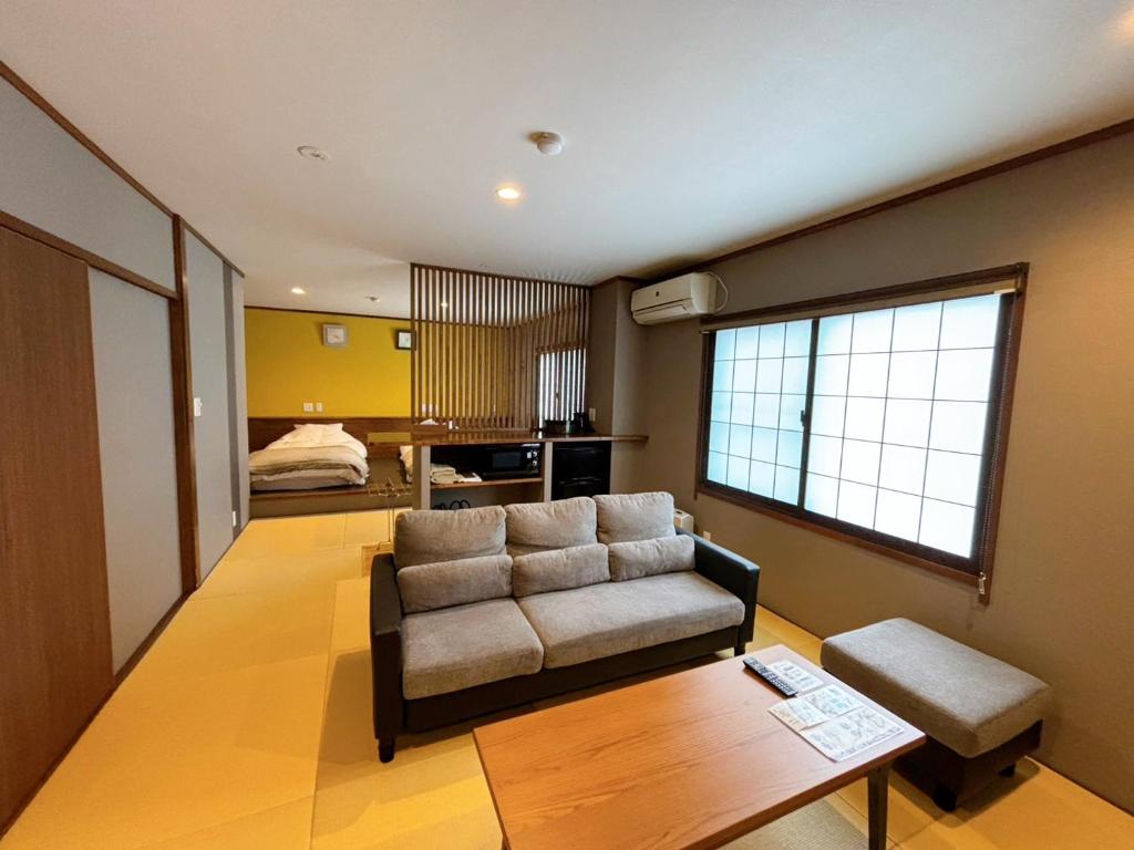 un salon avec un canapé et une table dans l'établissement Nozawa Onsen Azegamikan, à Nozawa Onsen