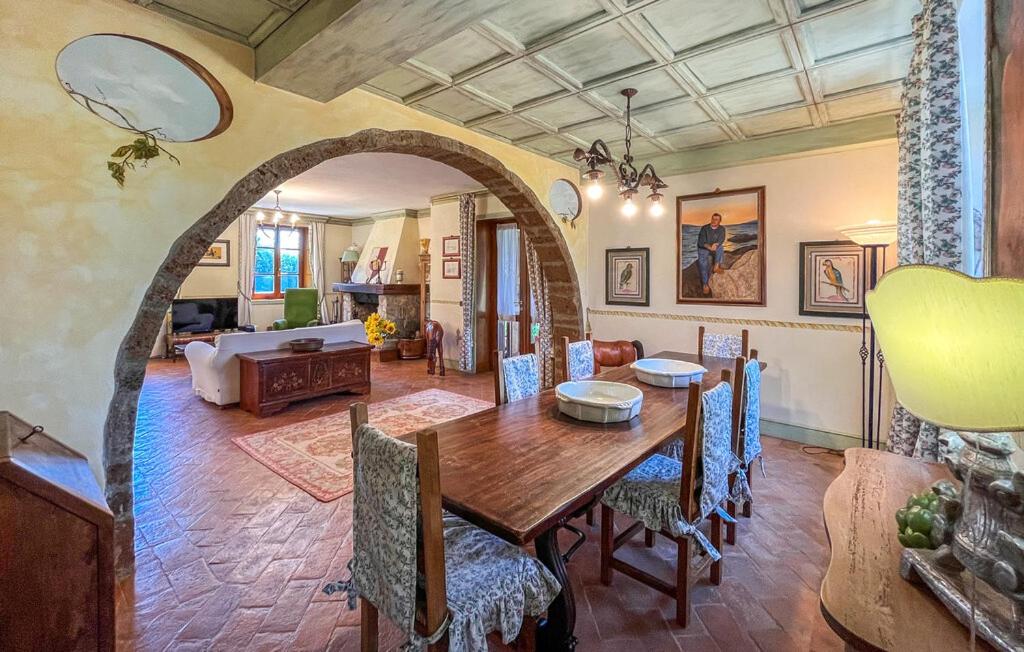 une salle à manger avec une table et un salon dans l'établissement Luxury Villa with pool by Varental, à Melezzole