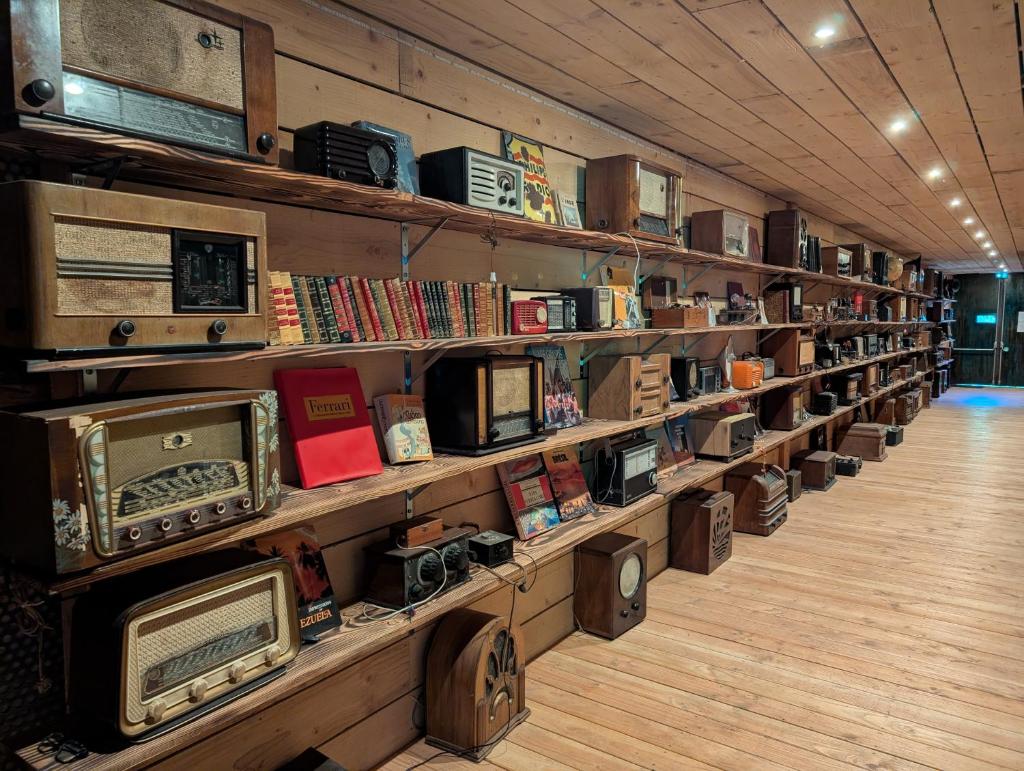 une bibliothèque remplie d'étagères remplies de vieilles radios dans l'établissement Cabane perchée - lac privé, spa & nature, à Sadirac