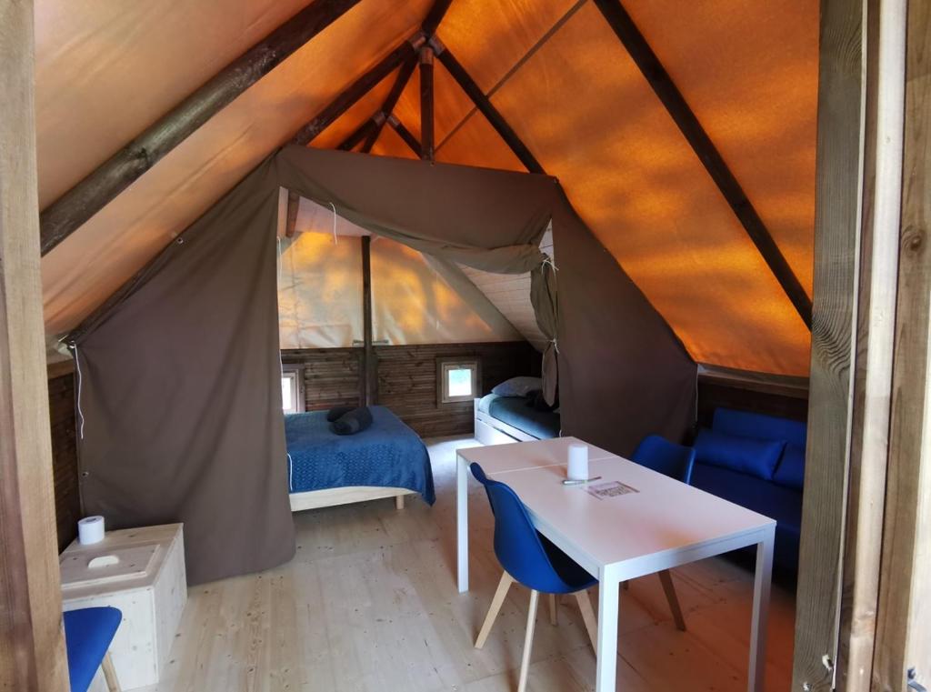 Cette chambre comprend une tente avec une table et un lit. dans l'établissement La Parenthèse Meslandaise, à Mesland