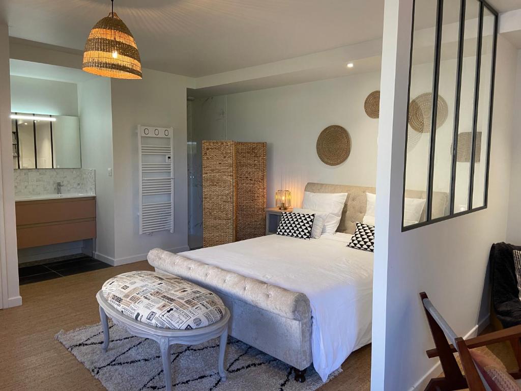 - une chambre avec un lit et une table ainsi qu'une salle de bains dans l'établissement Les logis du forgeron, Gites de groupe entre Loire & vignes, à Saint-Jean-des-Mauvrets 37 autres photos