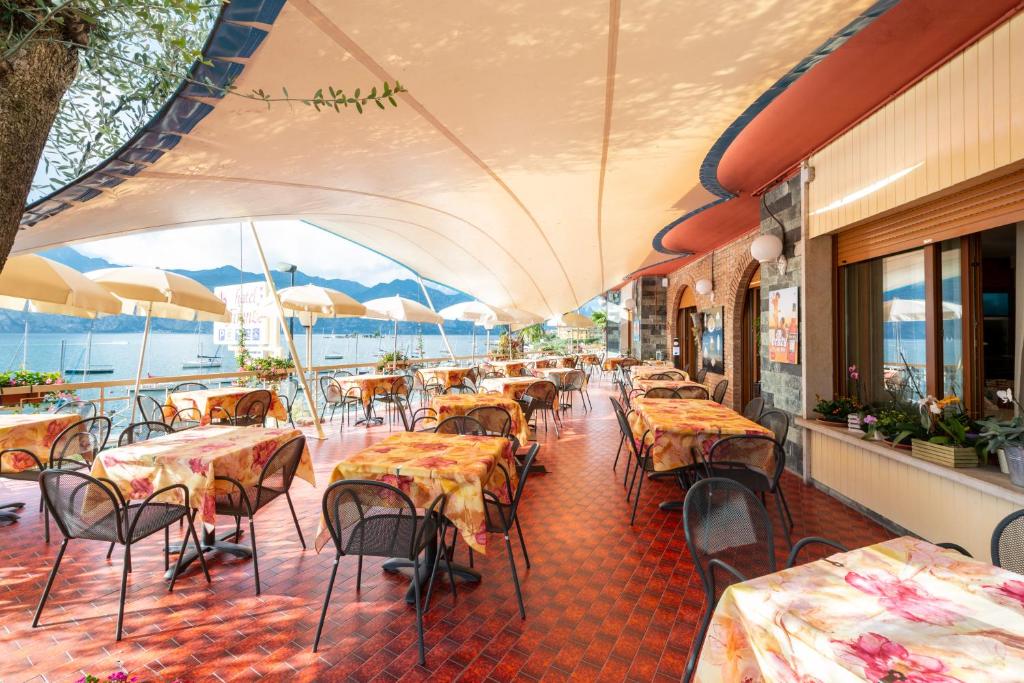 un restaurant avec des tables et des chaises dans une salle dans l'établissement Hotel Firenze 3 Stelle Superior, à Brenzone