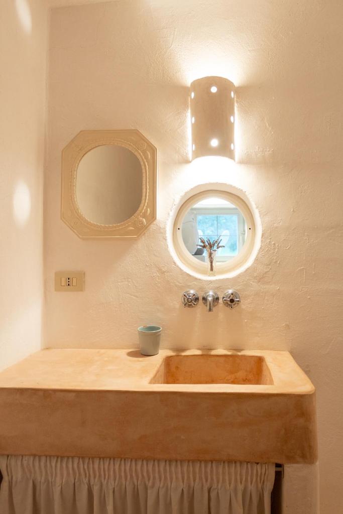 une salle de bain avec un lavabo en bois et un miroir dans l'établissement Accademia degli Inquieti - Casina Gargiulo, à Ceglie Messapica
