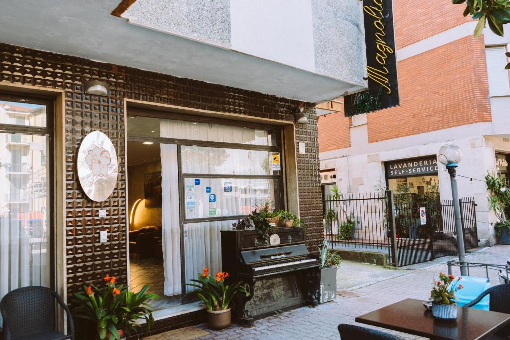une façade de magasin d'un bâtiment en briques avec une fenêtre dans l'établissement Hotel Magnolia, à Albenga