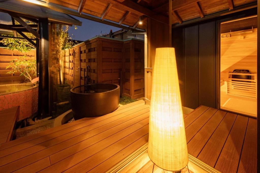 une grande terrasse avec une baignoire et une lumière dessus dans l'établissement Hanashibuki, à Tateyama