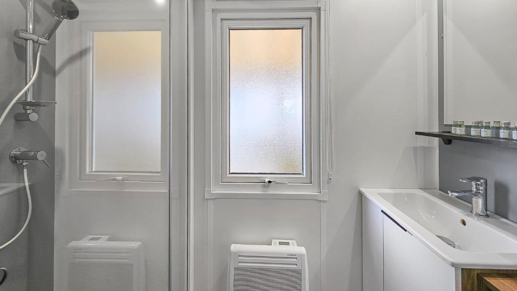 une salle de bain avec une fenêtre, des toilettes et un lavabo dans l'établissement Bora bora 2023, à Le Perron