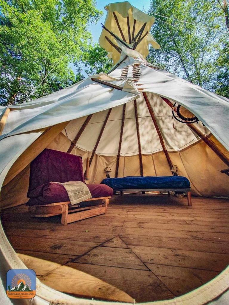 une tente avec un lit et un banc. dans l'établissement Camping 2 étoiles - Piscine - ccb0hef, à Fenouillet