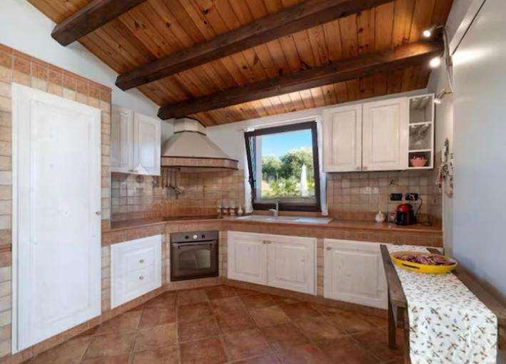 une grande cuisine avec des armoires blanches et une fenêtre dans l'établissement Villa Marylove - Scicli 200m dal mare, à Cava dʼAliga
