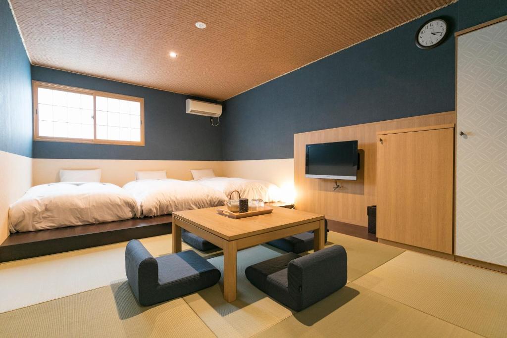 une chambre avec un lit, une table et des chaises dans l'établissement Asobe, à Aso