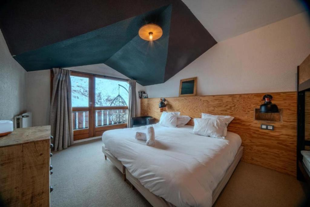 une chambre avec un grand lit avec un plafond bleu dans l'établissement Alpeen Hotel, aux Menuires