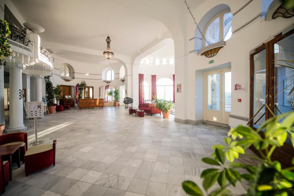 un hall vide avec des tables et des chaises dans un bâtiment dans l'établissement Villages Clubs du Soleil - SUPERBAGNERES, à Superbagnères