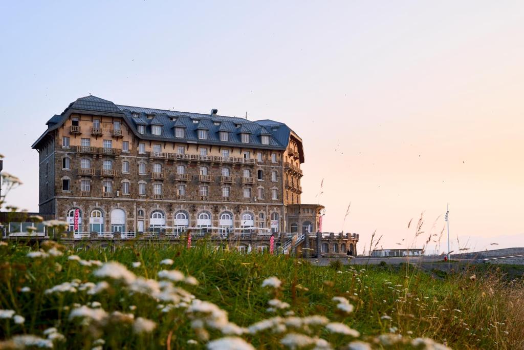 un grand bâtiment au-dessus d'un champ verdoyant dans l'établissement Villages Clubs du Soleil - SUPERBAGNERES, à Superbagnères