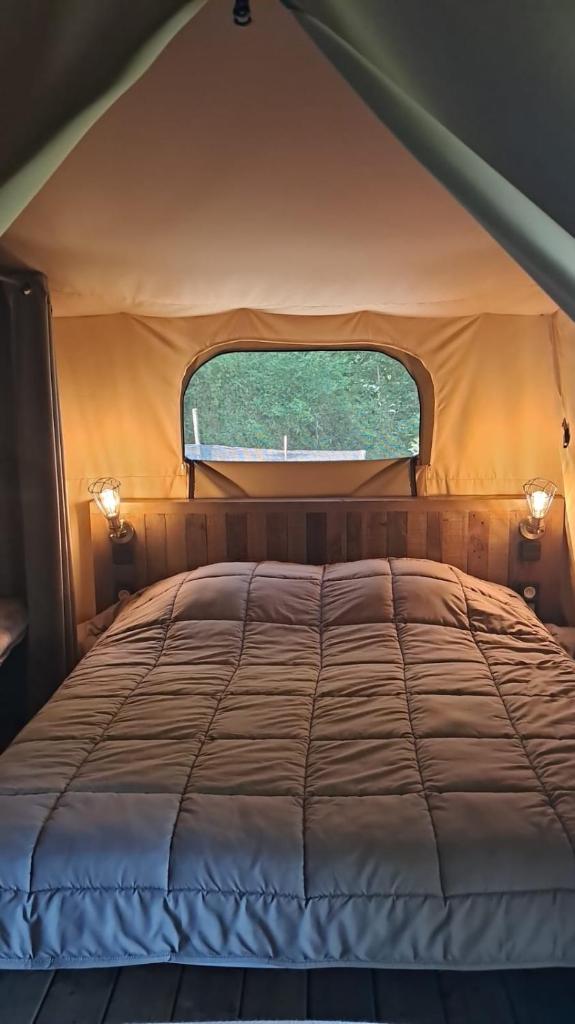 - un lit dans une tente avec fenêtre dans l'établissement O'PHIL DE LAU, à Manciet