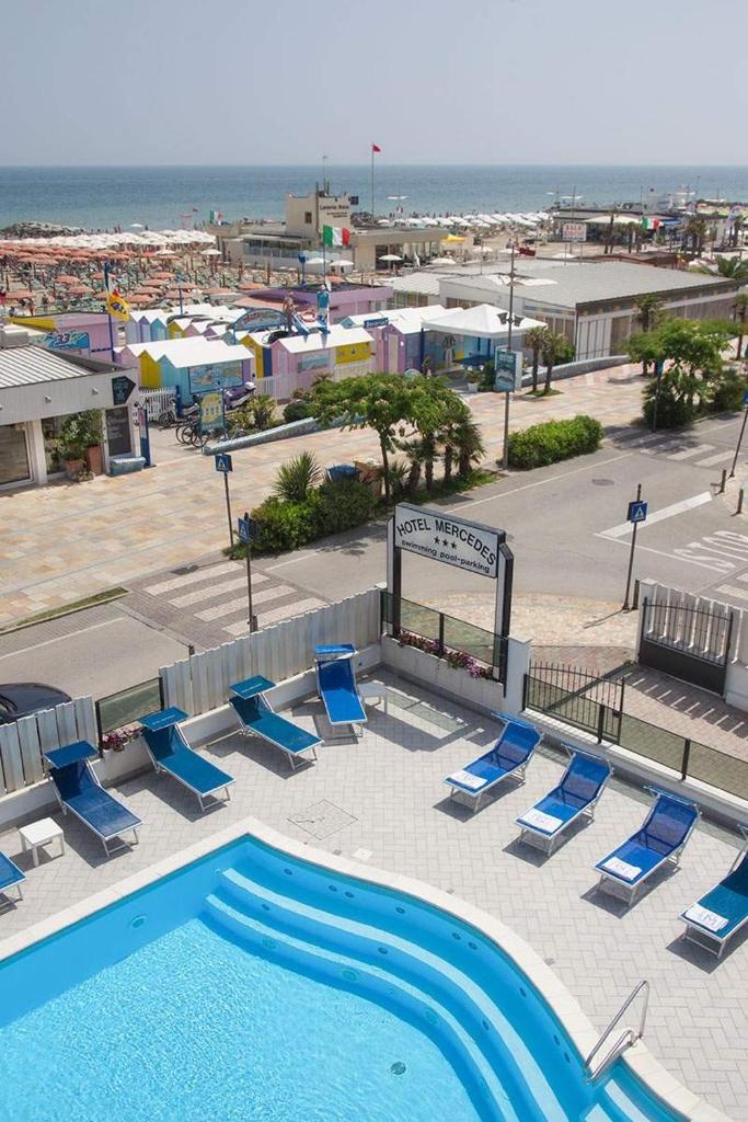 - une piscine avec des chaises longues et la plage dans l'établissement Hotel Mercedes, à Misano Adriatico