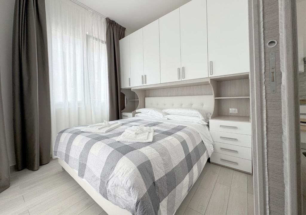 une chambre avec un lit avec une couverture noire et blanche dans l'établissement chiAma Hotel, à Rimini