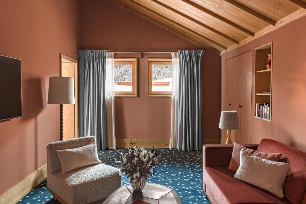 un salon avec un canapé, des chaises et une table dans l'établissement Hotel Le Coucou Méribel, à Méribel