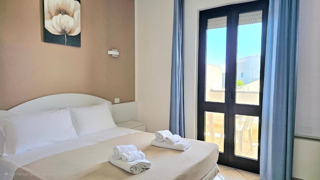une chambre avec un lit avec des serviettes dessus dans l'établissement Hotel Baia del Cigno, à Torre San Giovanni