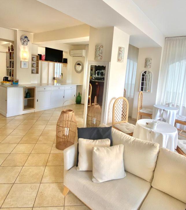 un salon avec un canapé blanc et une cuisine dans l'établissement Hotel Sylesia, à Letojanni 27 autres photos