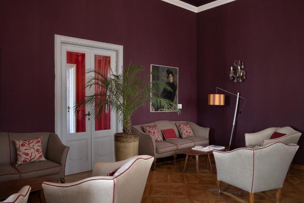 un salon avec des murs et des canapés violets dans l'établissement Palace Hotel, à Viareggio 111 autres photos
