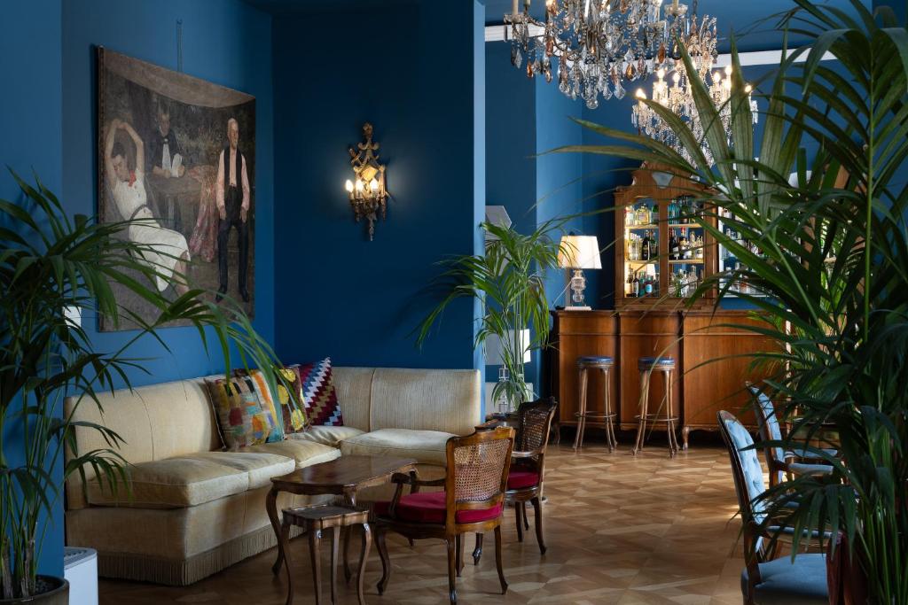 un salon avec un canapé, une table et des chaises dans l'établissement Palace Hotel, à Viareggio