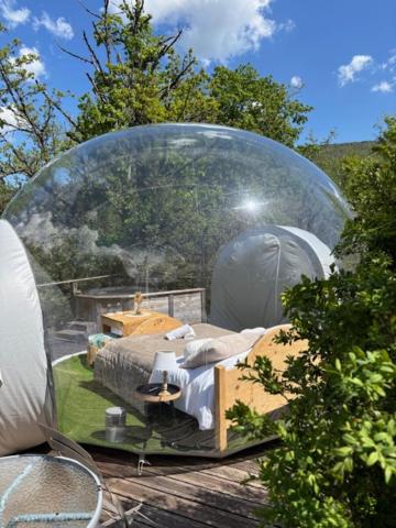 - un lit dans un dôme en verre dans un jardin dans l'établissement Bulle transparente, à Champfromier