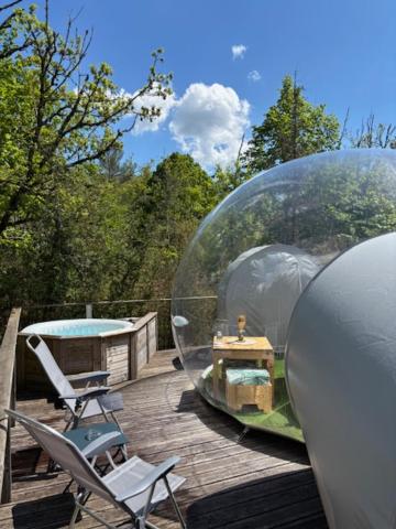 un dôme en verre avec une table et des chaises sur une terrasse dans l'établissement Bulle transparente, à Champfromier