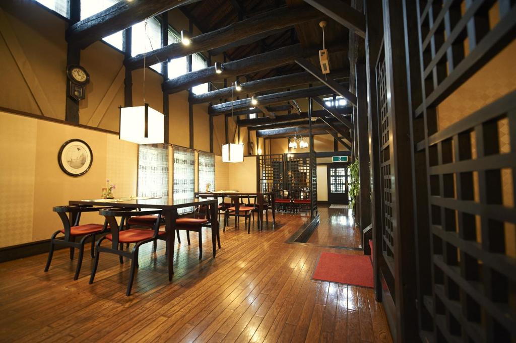 une salle à manger avec des tables et des chaises et une horloge dans l'établissement Hotel Kazahaya, à Hita