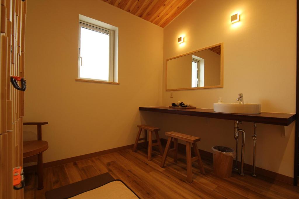 une salle de bain avec un lavabo et un miroir dans l'établissement Hotel Kifu Club Shiretoko, à Shari