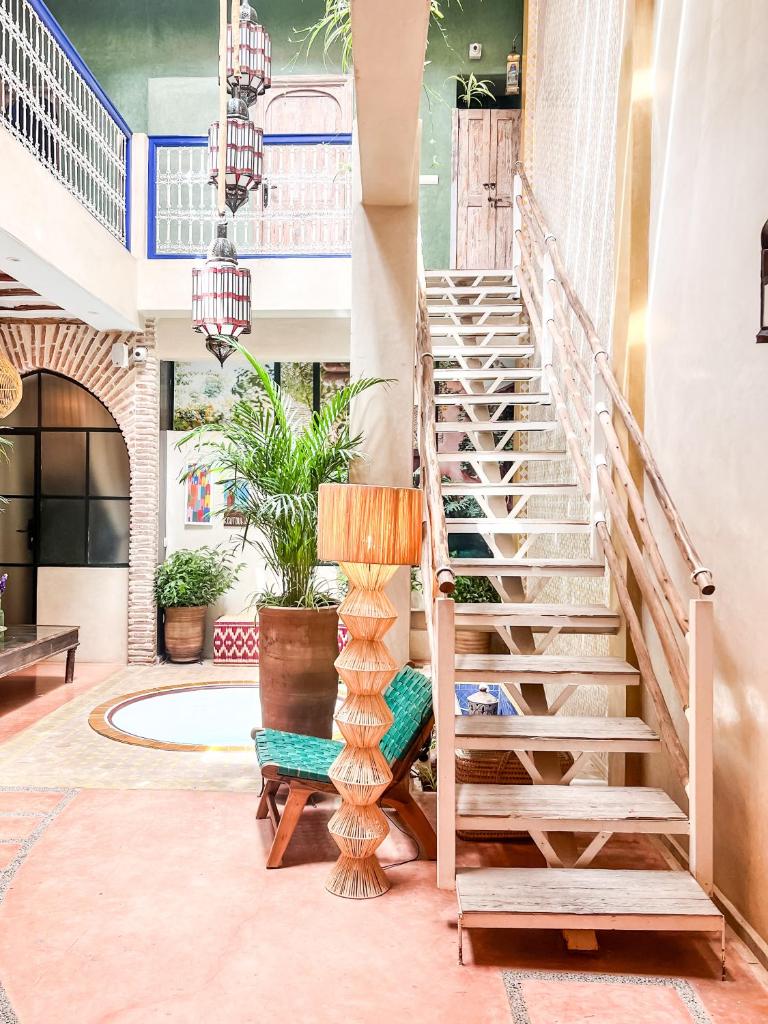un escalier dans un immeuble avec une chaise et une lampe dans l'établissement Riad 10 Mandarin BOUTIQUE RIAD, à Marrakech