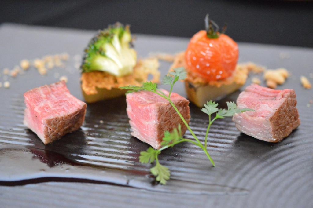 une assiette de nourriture avec de la viande et une fraise dessus dans l'établissement Tokachigawa Moor Onsen Seijyakubow, à Otofuke