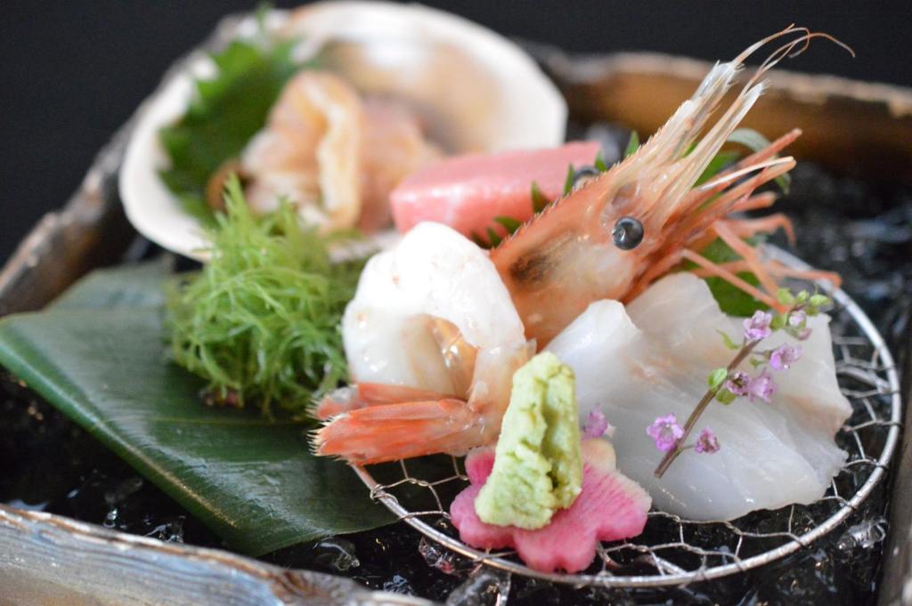 une assiette de nourriture avec une crevette et d'autres aliments dans l'établissement Tokachigawa Moor Onsen Seijyakubow, à Otofuke