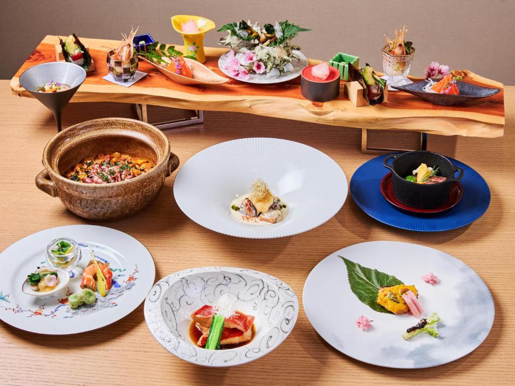 une table avec des assiettes de nourriture sur une table dans l'établissement Atami Izusan Karaku, à Atami
