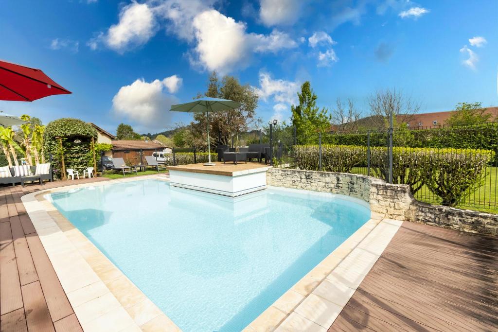 une piscine avec une table et un parasol dans l'établissement Maloan, gite avec piscine, à Saint-Julien-de-Lampon