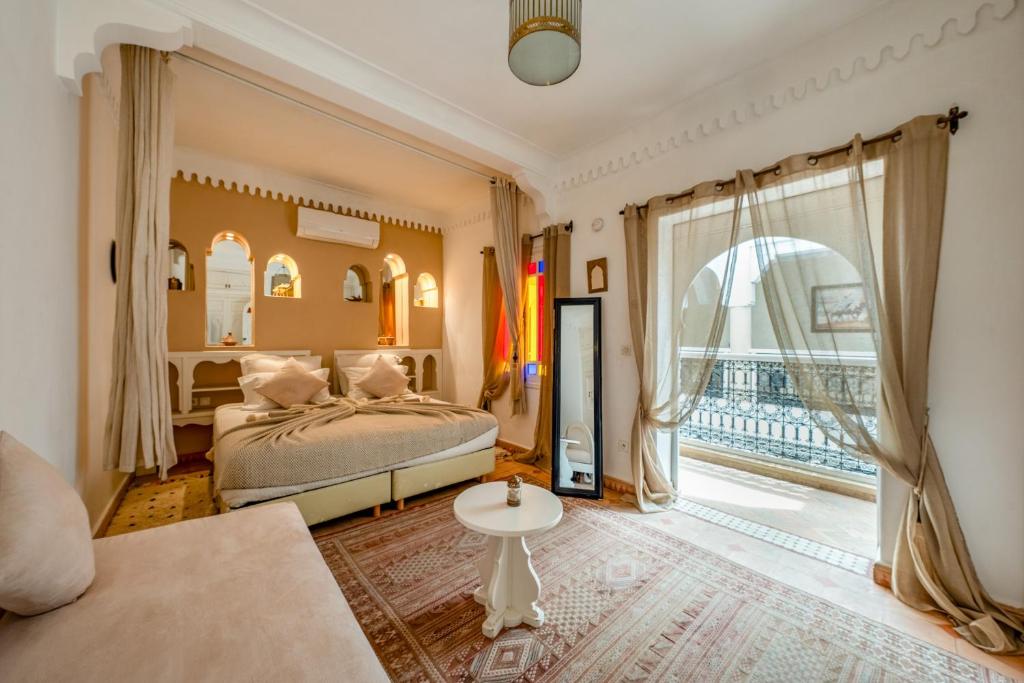 une chambre avec un lit et une grande fenêtre dans l'établissement RIAD AWINATI Location Privatisée ,piscine chauffée , beau Rooftop, à Marrakech