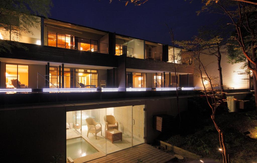 une maison avec 2 chaises et une piscine la nuit dans l'établissement Kitanokaze Saryo (Adult Only), à Hakone