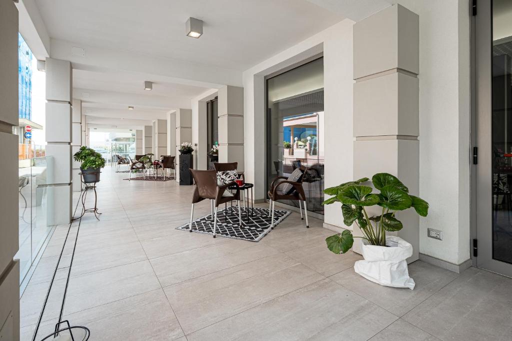 un couloir avec des chaises et des plantes dans un bâtiment dans l'établissement BI Hotel, à Bellaria-Igea Marina