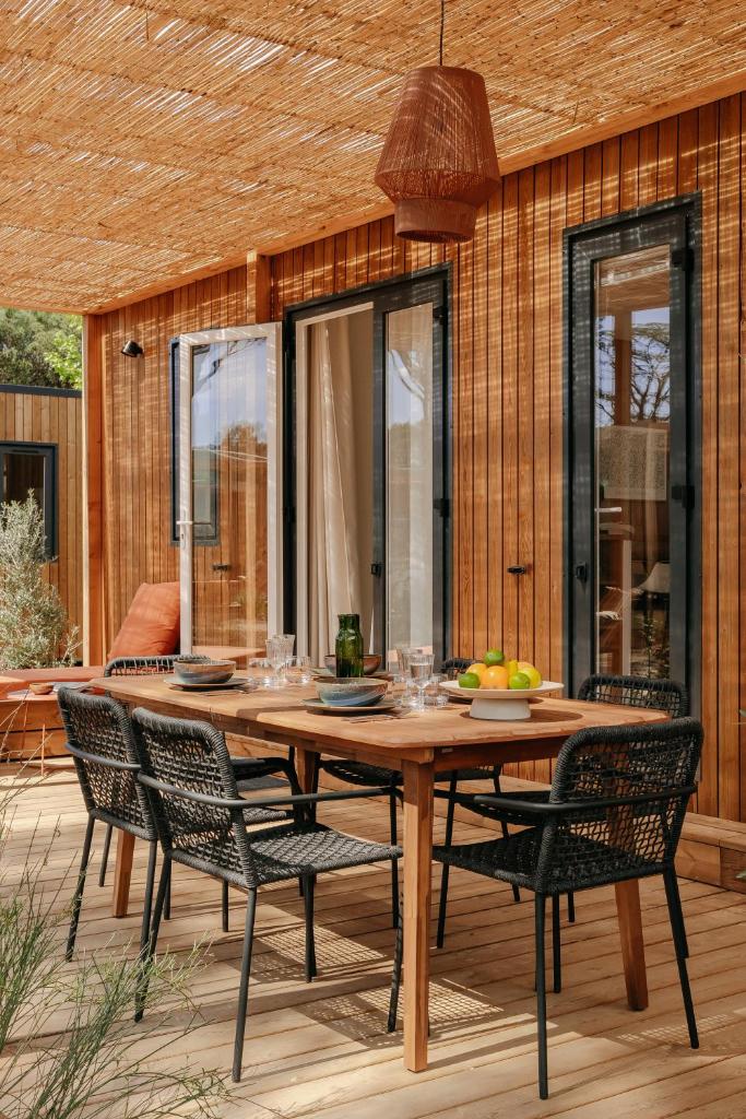 une table et des chaises en bois sur une terrasse dans l'établissement Domaine de Verdagne, à Gassin