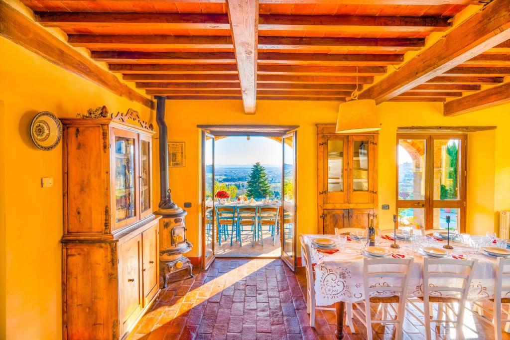 une salle à manger avec des murs jaunes et une table avec des chaises blanches dans l'établissement Villa Senaia, à Castiglion Fiorentino