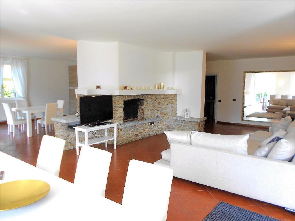 Elle comprend un salon doté d'un mobilier blanc et d'une cheminée. dans l'établissement Villa Oliva, à Tremezzo