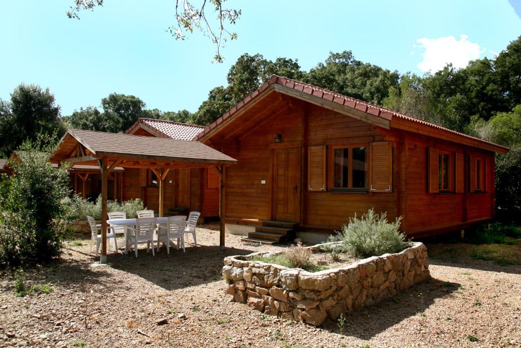 une cabine avec une table et des chaises devant elle dans l'établissement Camping U STABIACCIU, à Porto-Vecchio