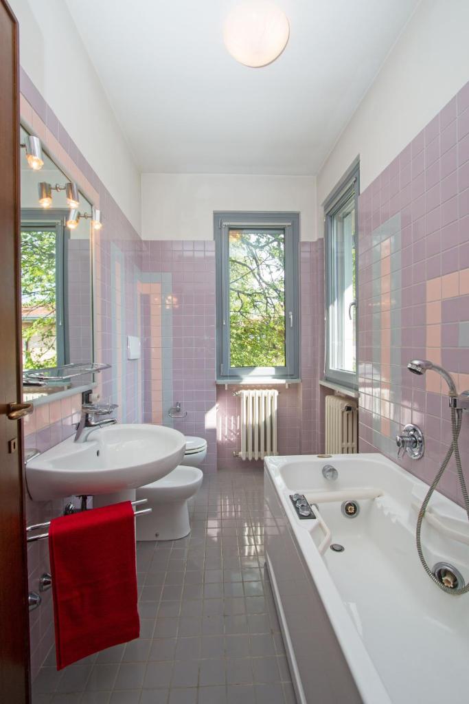 une salle de bain avec une baignoire, un lavabo et des toilettes dans l'établissement Villa dei Salici con Piscina by Wonderful Italy, à Soiano del Lago