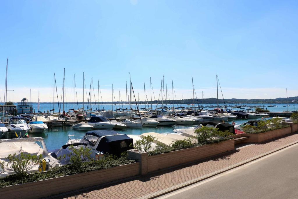 un groupe de bateaux amarrés dans un port dans l'établissement Villa dei Salici con Piscina by Wonderful Italy, à Soiano del Lago