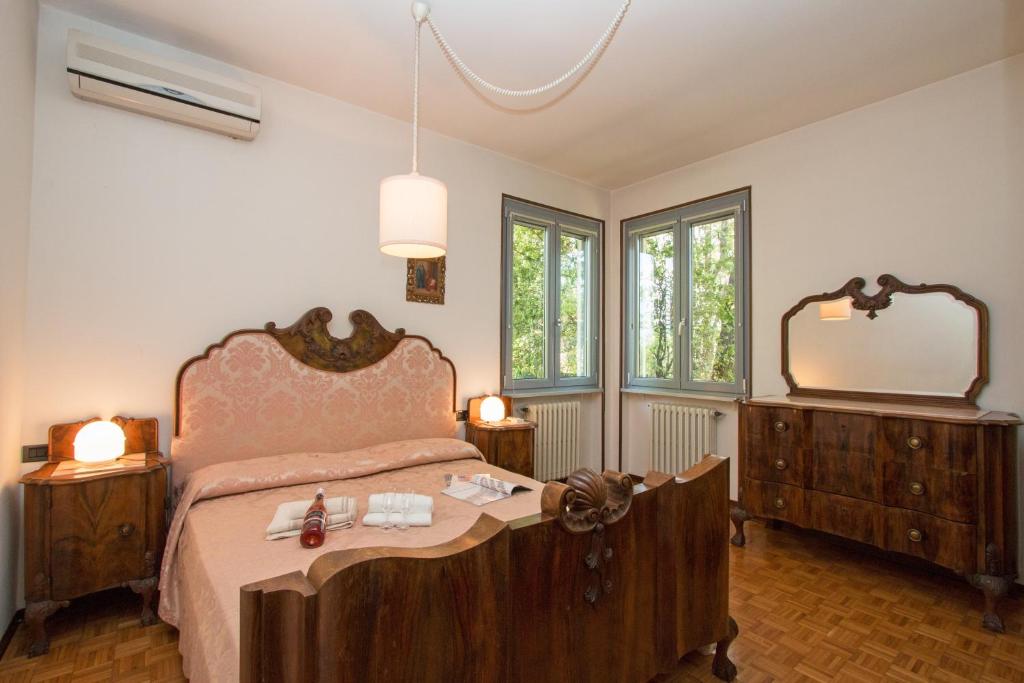 une chambre avec un grand lit et un miroir dans l'établissement Villa dei Salici con Piscina by Wonderful Italy, à Soiano del Lago 39 autres photos