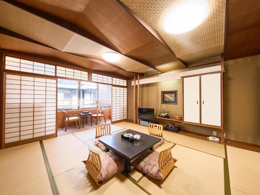 un salon avec une table et une salle à manger dans l'établissement Sinonomesou Kinosaki Onsen, à Toyooka